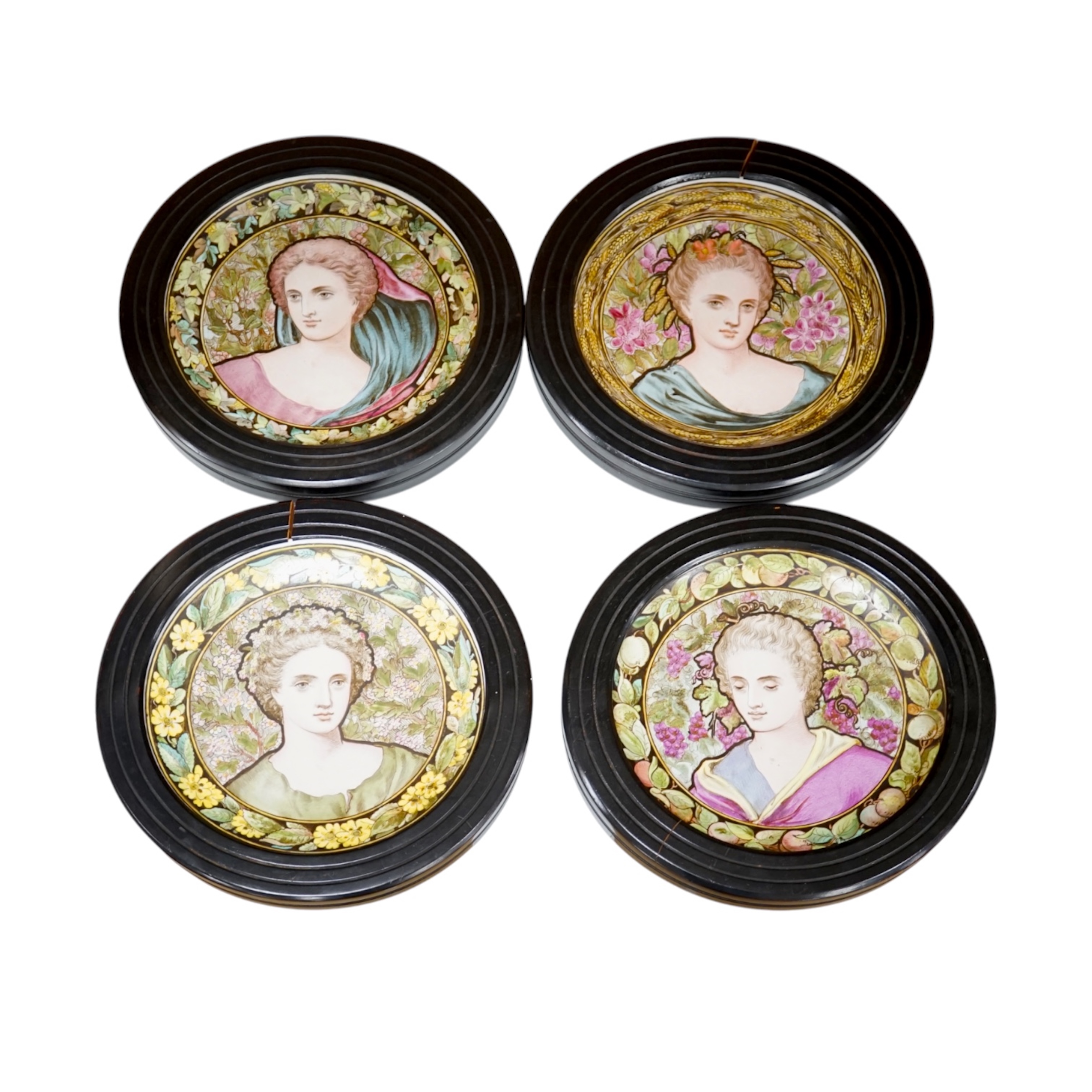 A set of four Copeland Spode Aesthetic period, outside decorated four seasons portrait plates, circa 1880, housed in ebonised wood frames, overall 31cm in diameter. Condition - fair, three frames cracked